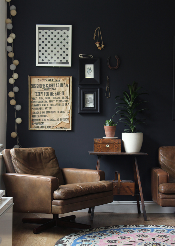Dark blue sitting room with brown chairs