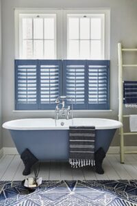 Blue sash window shutters in the bathroom open