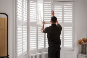 Man fitting shutters