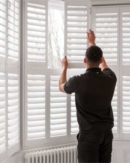 Man fitting shutters